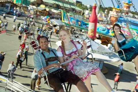 Couple having fun on chain carousel Ketten-Karussell at Oktoberfest Foto stock