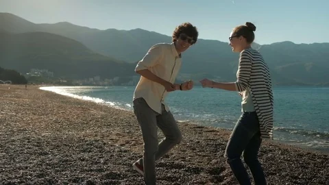 Couple having fun dancing in the sunset on the beach. Video stock 77609989