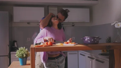 Couple having fun in the kitchen while making salad Stock Footage 97646746