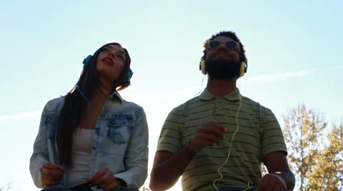 Couple having fun listening to music with headphones on sunny day Stock Footage 59555400