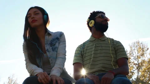 Couple having fun listening to music with headphones on sunny day Stock Footage 59555436