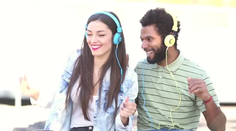 Couple having fun listening to music with headphones and dancing Stock Footage 59555566
