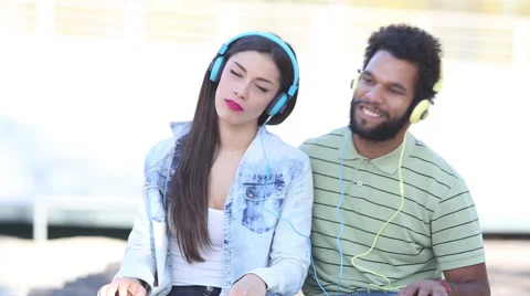Couple having fun listening to music with headphones and dancing Stock Footage 59555571