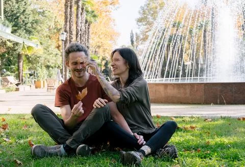 Couple having fun with maple yellow leaf in autumn park, romantic happy dat.. Stock Photos