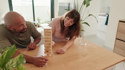 Couple Having Fun Playing Jenga at Home Stock Footage 318459601
