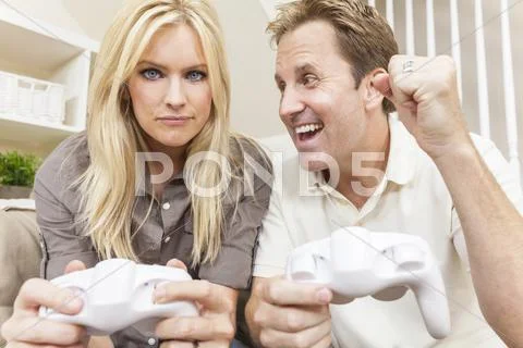 Couple having fun playing video console game Stock Photos