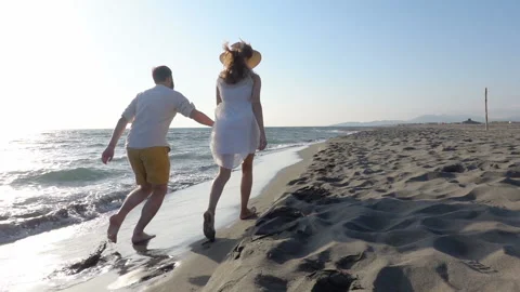 Couple having fun running along the beach near the water Video stock 118437437