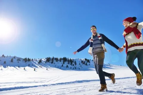 Couple having fun running down slope Foto stock