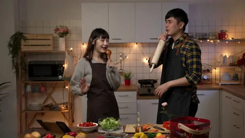Couple having fun singing together in kitchen Video stock 168750107