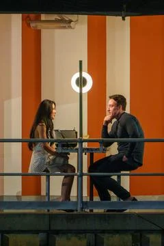 Couple having an intimate conversation at a table with a glowing circular l.. Stock Photos