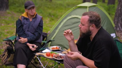 Couple having picnic while camping in the forest Stock Footage 327132656