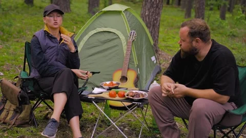 Couple having picnic while camping in the forest Stock Footage 327132674