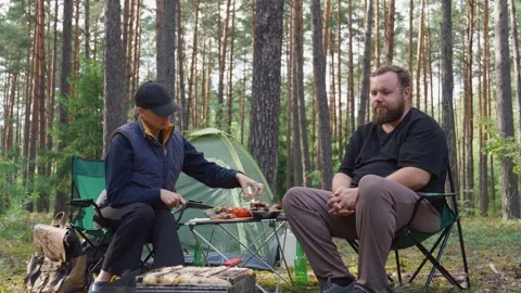 Couple having picnic while camping in pine forest Stock Footage 327136746