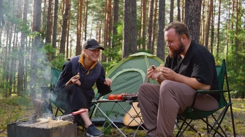Couple having picnic while camping in pine forest 库存影片 327136827