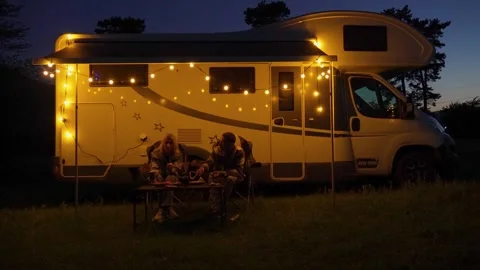 Couple having romantic dinner outside camper van at night 库存影片 340889739