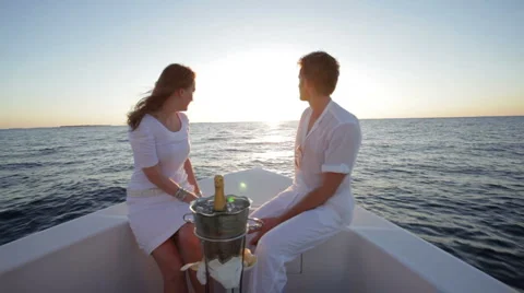 Couple heading into sunset on a boat Stock Footage 1008059