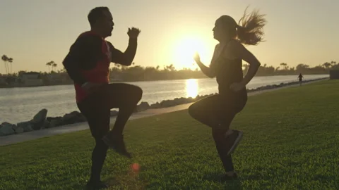 Couple high-step workout exercise together at sunset in silhouette (SLOW MOTION) Vídeos de archivo 136018446