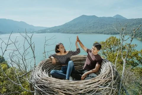 Couple highfive together while sitting on a nest Stock Photos