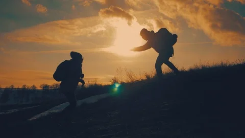 Couple hiking help each other silhouette in mountains. Teamwork couple hiking Stock Footage 105561754