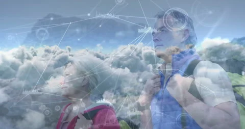 Couple hiking on mountain ridge, exploring tech network charts with clouds and Stock Footage 308099559
