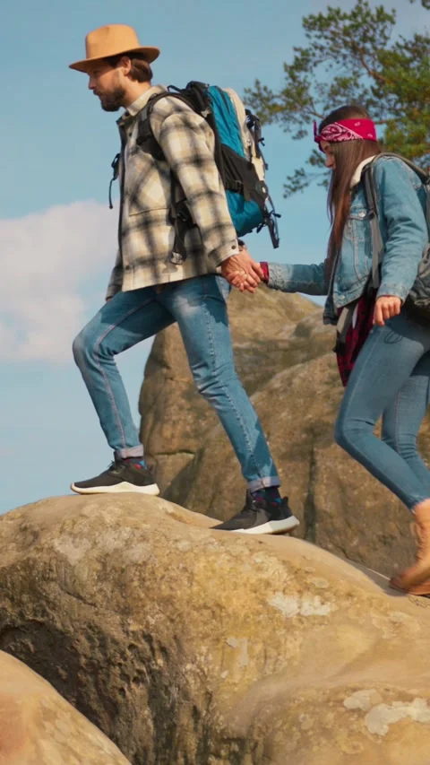 A couple is hiking together while exploring rocky terrain amidst beautiful Stock Footage 316514049