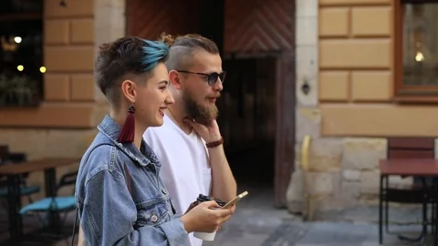 Couple of hipsters go talking, the guy looks at the girl, the camera moves from Video stock 101019420