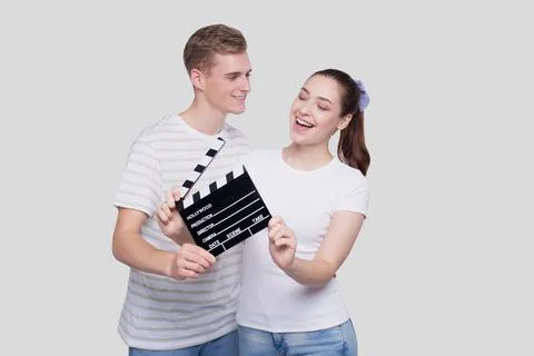 Couple Holding Clapperboard Looking at Each Other Isolated. Couple Movie Concept Stock Photos