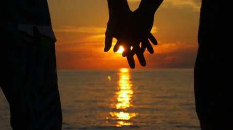 Couple holding hand at ocean sunset Stock Footage