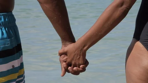 Couple holding hands on a beach. 스톡 동영상 88367892