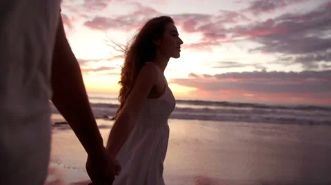 Couple holding hands during romantic sunset at the beach Stock Footage