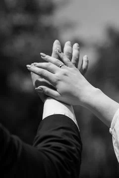 Couple holding hands with engagement ring in black and white cinematic styl.. Stock Photos