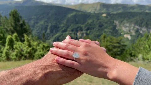 Couple holding hands featuring oval diamond engagement ring in Montenegro Video stock 319450004