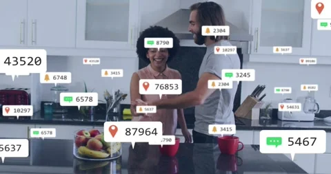 Couple holding hands at kitchen bar dancing while multiplying social media icons Stock Footage 320506315