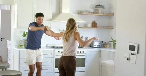 Couple holding hands, man lifting woman's hand and leading twirls for fun in Stock Footage 340614032
