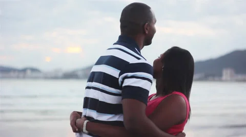 Couple holding hands at sunset silhouetted Stock Footage 32398061
