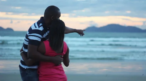 Couple holding hands at sunset silhouetted Stock Footage 32398076