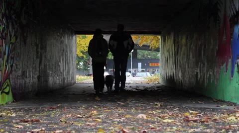 A couple holding hands walking through an underpass Stock Footage 33828667