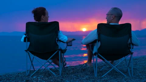 Couple holding hands watching setting sun Stock Footage 297607694