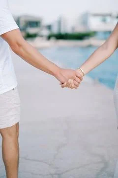 Couple Holding Hands by Waterfront Path Stock Photos