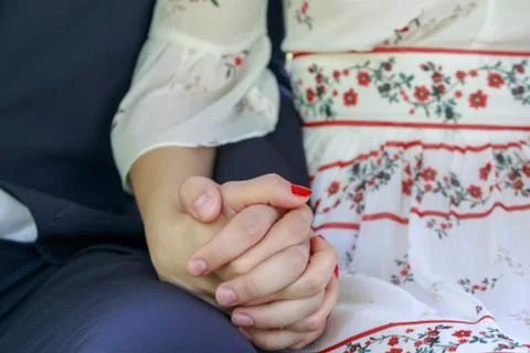 Couple holding hands while sitting together Stock Photos