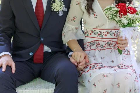 Couple holding hands while sitting together Stock Photos