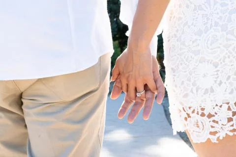 Couple holding hands while standing showing off ring Foto stock