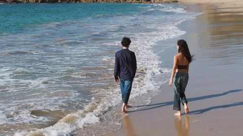 Couple Holding Hands While Walking At The Beach In Summer. - aerial shot Stock Footage 310954992