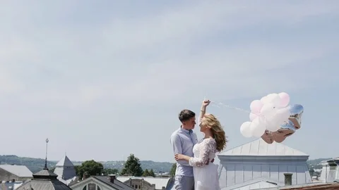 Couple holding some ballons on the rooftoop hugging and enjoys each other. Stock Footage 81296654