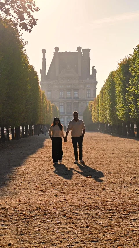 Couple holds hands while strolling through Tuileries Garden in Paris, France Video stock 347997756
