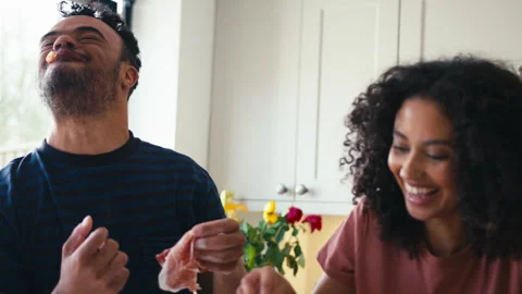 Couple At Home Adding And Eating Parma Ham Topping On Pizza In Kitchen Together Stock-Footage 253137126