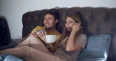 A couple at home lying in bed watching TV before bed. Slow motion. Video stock 145532258