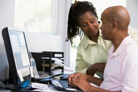 Couple in home office using computer 写真素材