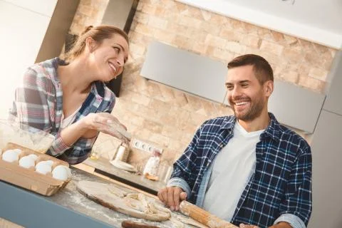 Couple at home standing in kitchen making pastry together smiling joyful Stock Photos