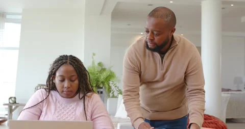 Couple at home table, man entering carrying blue mug and phone, leaning over Vídeo Stock 339495673